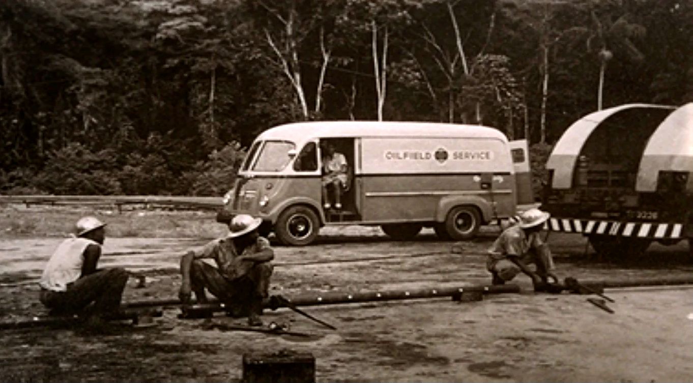 Archive photograph of a crew working on pipe in front of an Oilfield Service van